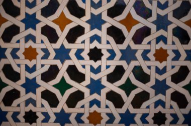 Ornamental colourful geometric medieval ceramic tiles of walls in old castle, Sevilla or Granada, Andalusia, Spain. Arabic mudejar style ornament background wallpaper clipart