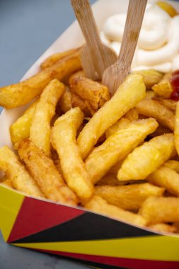 Belçika sokağı ve fast food, Belçika bayrağı renginde kağıt kutu kızarmış patates cipsi, ketçap ve mayonez sosu,