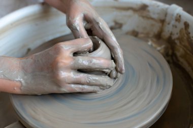 Polonya 'da modern sanat seramik atölyesinde atölye çalışması sırasında çömlekçi çarkında çamur tenceresi yapmak