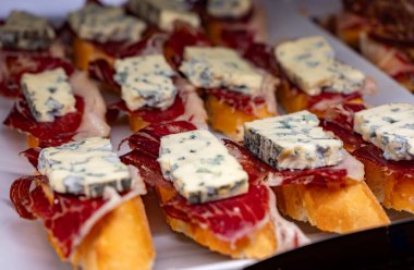 Bask ülkesinin tipik aperatifleri, küçük ekmek parçaları, deniz ürünleri, yumurta, peynir, San-Sebastian veya Bilbao, İspanya 'daki barlarda servis edilen jamon şişleriyle kapatılıyor.