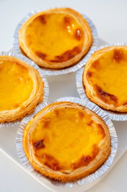 Portekiz 'in geleneksel tatlı tatlısı Pastel de nata yumurtalı kremalı tart pastası. Beyaz arka planda yakın plan.