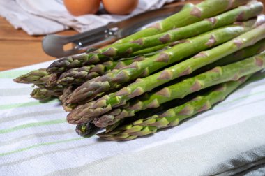 Bir demet taze, olgun yeşil kuşkonmaz pişmeye ya da ızgara yapmaya hazır organik sebzeler.