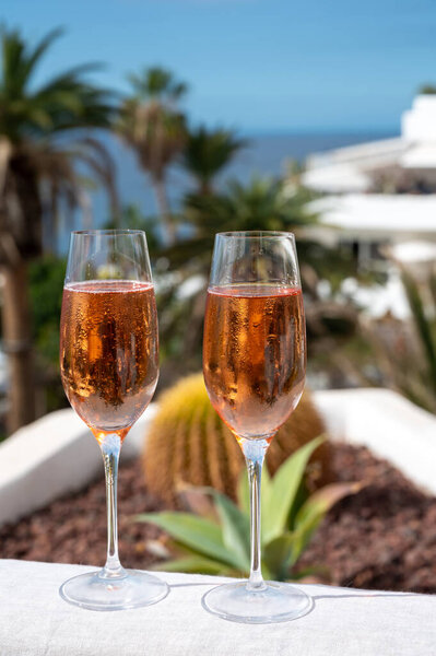 Celebration, birthday party, drinking of rose cava or champagne sparkling wine outdoor in vacation resort Costa Adeje, Tenerife, Canary islands winter sun vacation, Spain