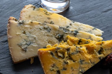 Peynir tabağı, İngiliz sütü yarı yumuşak, parçalanmış mavi ayaklık ve mavi sarı shropshire peyniri yakın, peynir tatma çiftliği, dilimlenmiş peynir