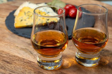 Viski ve peynir eşleşmesi, viski kadehleri ve dilimlenmiş eski mavi stilton ve mavi shropshire peynirleri, İngiltere 'nin yiyecek ve içeceği.