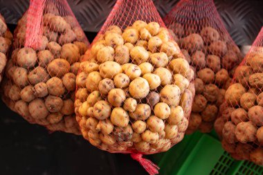 Küçük tatlı patates papalar markette, ana yemek kanarya adalarında, çok tuzlu pişirilmiş ve mojo sosuyla servis edilmiş, ağlarda asılı.