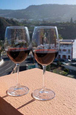 Tenerife 'deki Ycoden-Daute-Isora Dağı' nın volkanik topraklarında şarap imalathanelerinde şarap üretiliyor. Kanarya Adaları kış tatili, İspanya, açık havada kırmızı şarap bardakları.