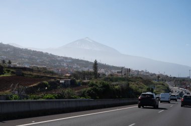 Tenerife 'nin kuzeyindeki Tenerife adasında kiralık arabayla seyahat ederken, tropikal bitkiler, dağlar, okyanus, kışın Teide Dağı manzarası