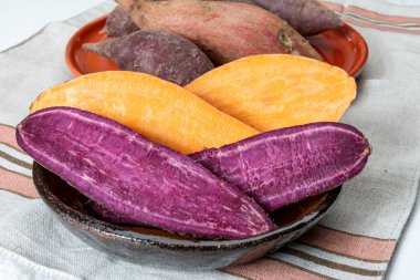 Renkli tatlı tadımlık tüberküloz kökleri mor ve turuncu organik tatlı patatesler, vejetaryen yemekleri, yakın plan.