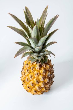 Taze olgun bir Fransız ananası ya da Mauritius 'tan gelen tatlı bebek ananasları. Beyaz arka planda.