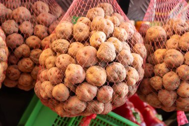 Küçük tatlı patates papalar markette, ana yemek kanarya adalarında, çok tuzlu pişirilmiş ve mojo sosuyla servis edilmiş, ağlarda asılı.