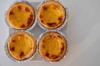 Portekiz 'in geleneksel tatlı tatlısı Pastel de nata yumurtalı kremalı tart pastası. Beyaz arka planda yakın plan.