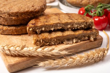 Tahıldan yapılmış yuvarlak vejetaryen köfteler ya da hamburgerler, hayati buğday glüten yiyecekler, pişirilmemiş ve ahşap kalaslarda kızartılmış.