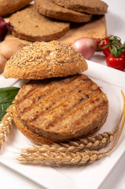 Vejetaryen veya vejetaryen köftelerden hamburgerler yapmak veya tahıldan yapılmış hamburgerler, hayati buğday glüten yemekleri, ızgara sağlıklı yiyecekler.