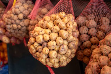 Küçük tatlı patates papalar markette, ana yemek kanarya adalarında, çok tuzlu pişirilmiş ve mojo sosuyla servis edilmiş, ağlarda asılı.