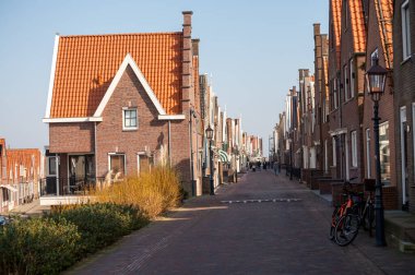 Kuzey Hollanda 'da turistler, Amsterdam yakınlarındaki eski otantik balıkçı köyü Volendam' da eski evler ve ilkbaharda dar sokaklar