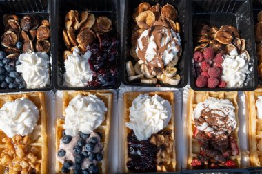 Farklı malzemelerle zenginleştirilmiş taze waffle çeşitleri, tatlı tatlılar, çikolata, krema, meyve ve meyveler, pastanede şekerleme dükkanı, eski Volendam, geleneksel Hollanda tatlıları