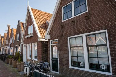 Kuzey Hollanda 'da turistler, Amsterdam yakınlarındaki eski otantik balıkçı köyü Volendam' da eski evler ve ilkbaharda dar sokaklar