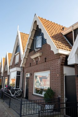 Kuzey Hollanda 'da turistler, Amsterdam yakınlarındaki eski otantik balıkçı köyü Volendam' da eski evler ve ilkbaharda dar sokaklar