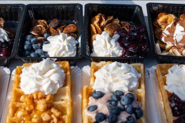 Farklı malzemelerle zenginleştirilmiş taze waffle çeşitleri, tatlı tatlılar, çikolata, krema, meyve ve meyveler, pastanede şekerleme dükkanı, eski Volendam, geleneksel Hollanda tatlıları