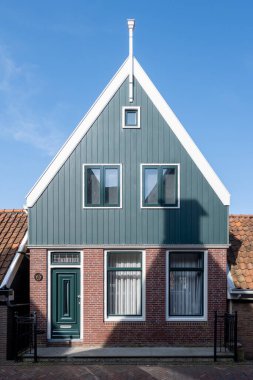 Kuzey Hollanda 'da turistler, Amsterdam yakınlarındaki eski otantik balıkçı köyü Volendam' da eski evler ve ilkbaharda dar sokaklar