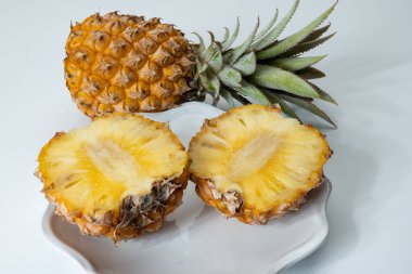 İki taze olgun Fransız ananası ya da Mauritius 'tan gelen tatlı bebek ananasları. Beyaz arka planda.