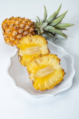 İki taze olgun Fransız ananası ya da Mauritius 'tan gelen tatlı bebek ananasları. Beyaz arka planda.