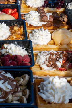 Farklı malzemelerle zenginleştirilmiş taze waffle çeşitleri, tatlı tatlılar, çikolata, krema, meyve ve meyveler, pastanede şekerleme dükkanı, eski Volendam, geleneksel Hollanda tatlıları
