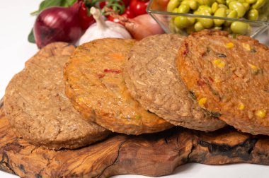 Pişmemiş vejetaryen köfteler veya hamburgerler tahıl, soya fasulyesi, sebze ve baklagillerden yapılır.
