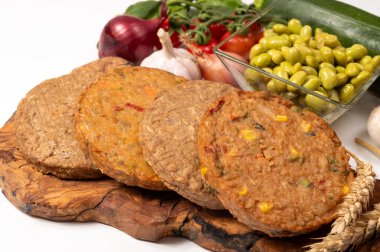 Pişmemiş vejetaryen köfteler veya hamburgerler tahıl, soya fasulyesi, sebze ve baklagillerden yapılır.