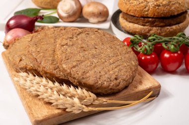 Tahıldan yapılmış yuvarlak vejetaryen köfteler ya da hamburgerler, hayati buğday glüten yiyecekler, pişirilmemiş ve ahşap kalaslarda kızartılmış.