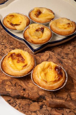 Portekiz 'in geleneksel tatlı tatlısı Pastel de nata yumurtalı kremalı tart pastası. Tahtaya yakın.