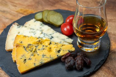 Viski ve peynir eşleşmesi, viski kadehleri ve dilimlenmiş eski mavi stilton ve mavi shropshire peynirleri, İngiltere 'nin yiyecek ve içeceği.