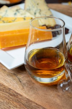 Viski ve peynir eşleşmesi, İskoç speyside viski bardakları ve dilimlenmiş çedar, mavi stilton ve mavi shropshire peyniri, İngiltere 'nin yiyecek ve içeceği.