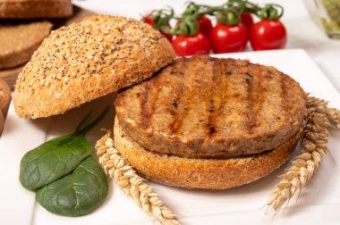 Vejetaryen veya vejetaryen köftelerden hamburgerler yapmak veya tahıldan yapılmış hamburgerler, hayati buğday glüten yemekleri, ızgara sağlıklı yiyecekler.