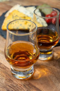 Viski ve peynir eşleşmesi, viski kadehleri ve dilimlenmiş eski mavi stilton ve mavi shropshire peynirleri, İngiltere 'nin yiyecek ve içeceği.