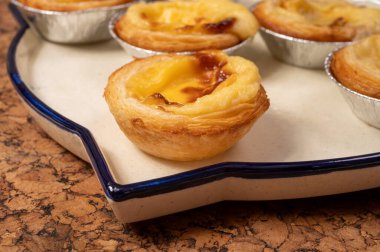 Portekiz 'in geleneksel tatlı tatlısı Pastel de nata yumurtalı kremalı tart pastası. Tahtaya yakın.