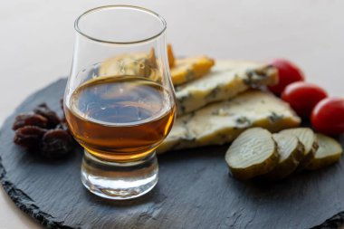 Viski ve peynir eşleştirme, viski bardağı ve tabağı tatma, dilimlenmiş eski mavi stilton ve mavi shropshire peyniri, İngiltere 'nin yiyecek ve içeceği.