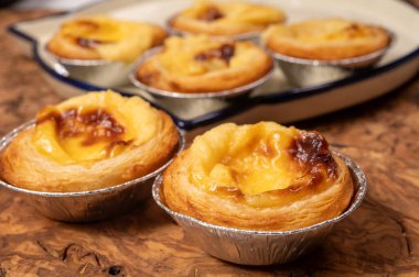 Portekiz 'in geleneksel tatlı tatlısı Pastel de nata yumurtalı kremalı tart pastası. Tahtaya yakın.