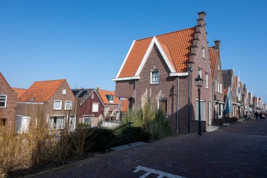 Kuzey Hollanda 'da turistler, Amsterdam yakınlarındaki eski otantik balıkçı köyü Volendam' da eski evler ve ilkbaharda dar sokaklar