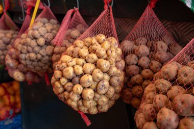 Küçük tatlı patates papalar markette, ana yemek kanarya adalarında, çok tuzlu pişirilmiş ve mojo sosuyla servis edilmiş, ağlarda asılı.