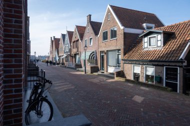 Kuzey Hollanda 'da turistler, Amsterdam yakınlarındaki eski otantik balıkçı köyü Volendam' da eski evler ve ilkbaharda dar sokaklar