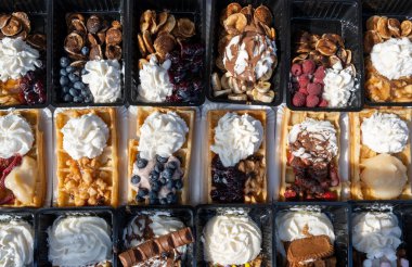 Farklı malzemelerle zenginleştirilmiş taze waffle çeşitleri, tatlı tatlılar, çikolata, krema, meyve ve meyveler, pastanede şekerleme dükkanı, eski Volendam, geleneksel Hollanda tatlıları