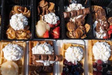Farklı malzemelerle zenginleştirilmiş taze waffle çeşitleri, tatlı tatlılar, çikolata, krema, meyve ve meyveler, pastanede şekerleme dükkanı, eski Volendam, geleneksel Hollanda tatlıları