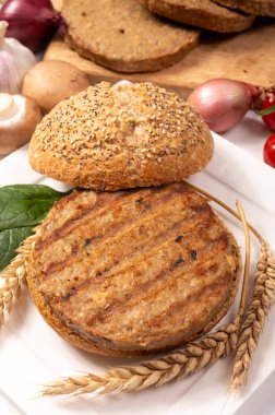 Vejetaryen veya vejetaryen köftelerden hamburgerler yapmak veya tahıldan yapılmış hamburgerler, hayati buğday glüten yemekleri, ızgara sağlıklı yiyecekler.