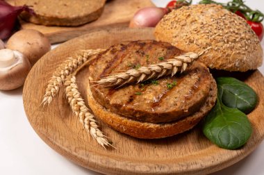 Vejetaryen veya vejetaryen köftelerden hamburgerler yapmak veya tahıldan yapılmış hamburgerler, hayati buğday glüten yemekleri, ızgara sağlıklı yiyecekler.