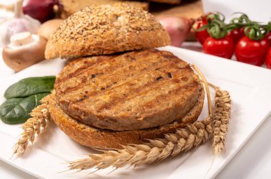 Vejetaryen veya vejetaryen köftelerden hamburgerler yapmak veya tahıldan yapılmış hamburgerler, hayati buğday glüten yemekleri, ızgara sağlıklı yiyecekler.