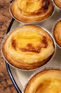 Portekiz 'in geleneksel tatlı tatlısı Pastel de nata yumurtalı kremalı tart pastası. Tahtaya yakın.