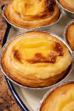 Portekiz 'in geleneksel tatlı tatlısı Pastel de nata yumurtalı kremalı tart pastası. Tahtaya yakın.