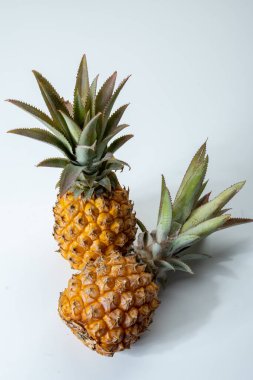 İki taze olgun Fransız ananası ya da Mauritius 'tan gelen tatlı bebek ananasları. Beyaz arka planda.
